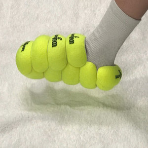 Una zapatilla hecha con pelotas de tenis. 