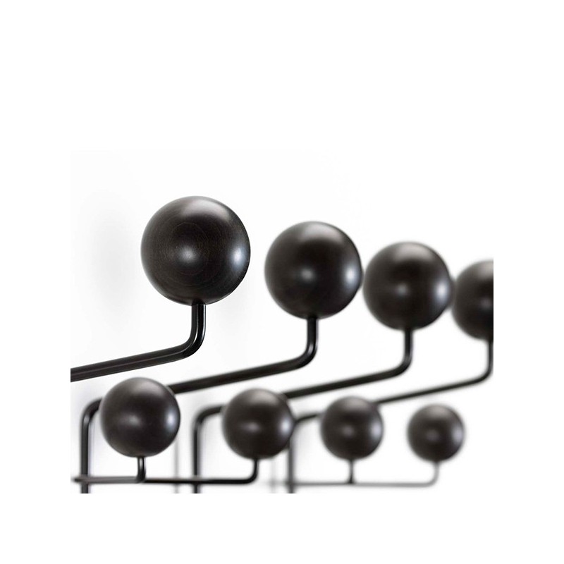 El perchero de Charles & Ray Eames está hecho con un cable de acero revestido en negro, con  bolas de madera. 