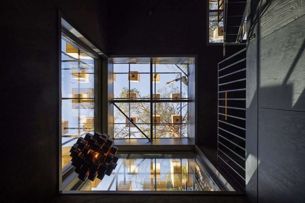 El interior de la habitación de hotel de 34 m2 incorpora ricos interiores oscuros y materiales orgánicos inspirados en el paisaje circundante. 