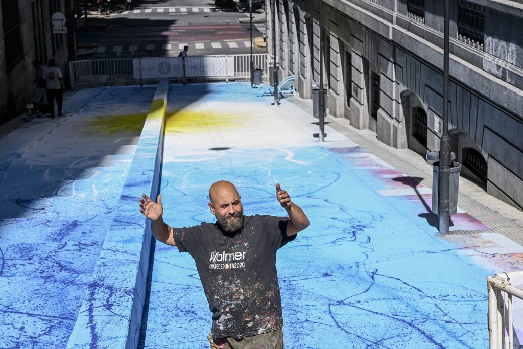 El muralista urbano Alfredo Segatori frente a su obra en el Microcentro porteño. 
