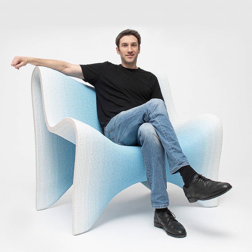 El diseñador austríaco Philipp Aduatz en su silla 3D de hormigón. 