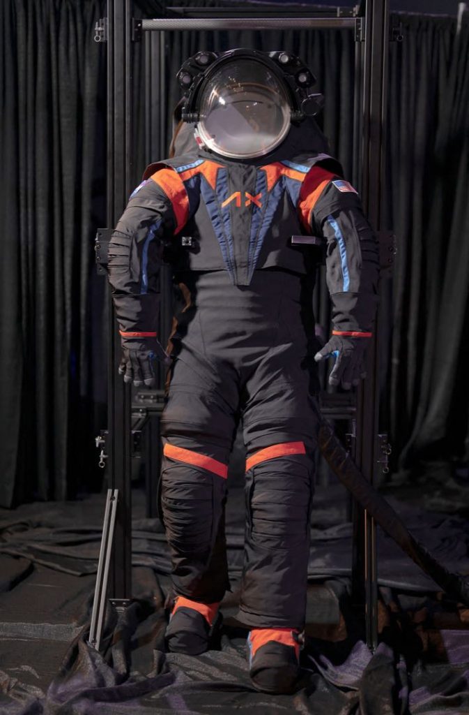 El nuevo traje espacial de la NASA, color gris carbón oscuro, con detalles en colores naranja y azul, y de diseño moderno.