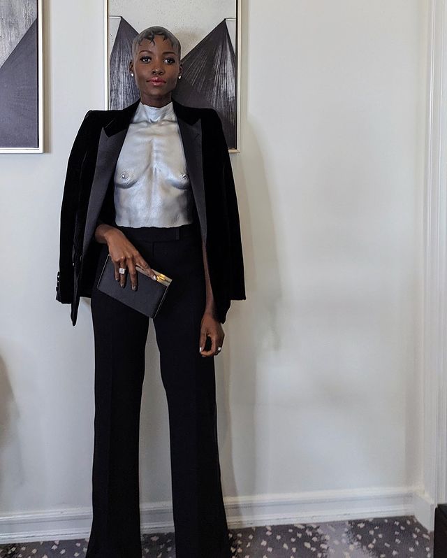 Lupita Nyong'o combinó el top plateado con pantalón ancho y blazer negro. 