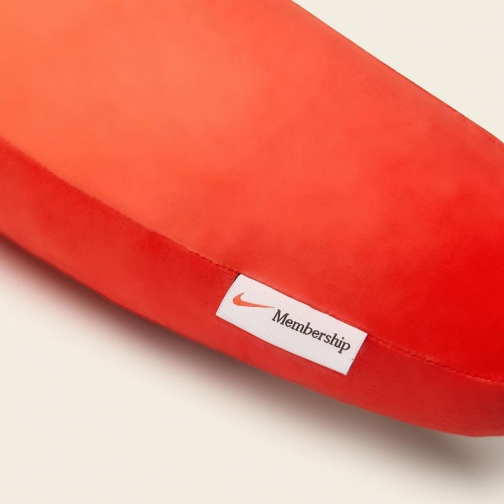 La almohada con la forma del Swoosh de Nike incluye una etiqueta de "Membresía". 