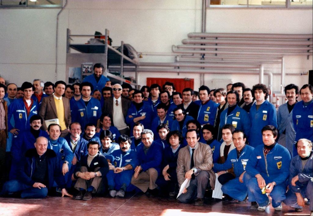 Enzo Ferrari con sus empleados vestidos de azul en la década de 1960. 