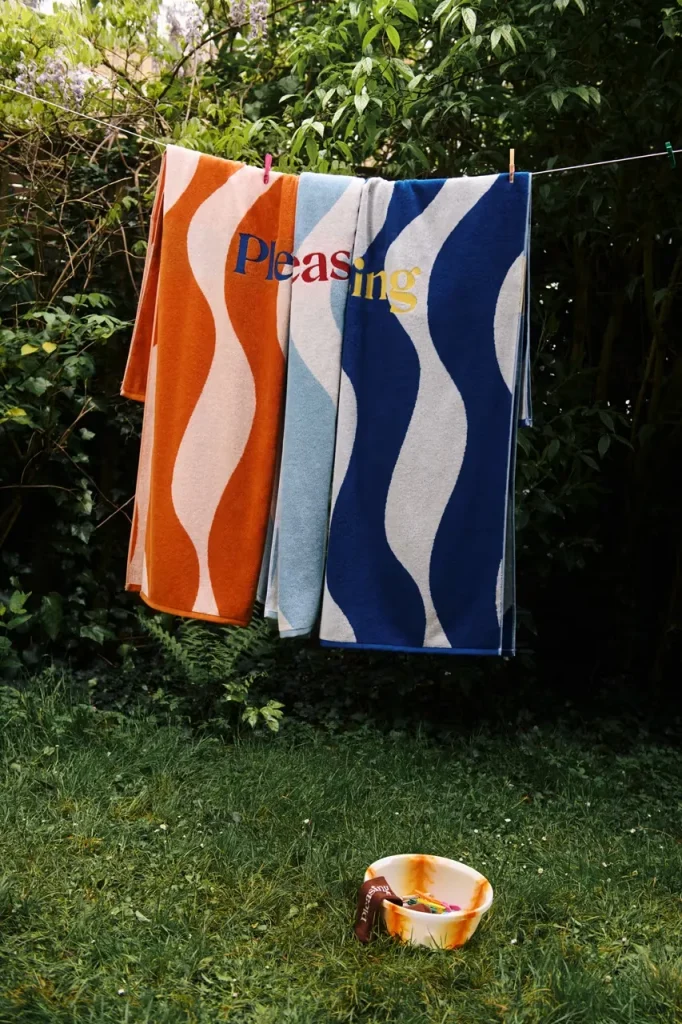 La primera colección de Pleasing de Harry Styles incluye toallas playeras. 