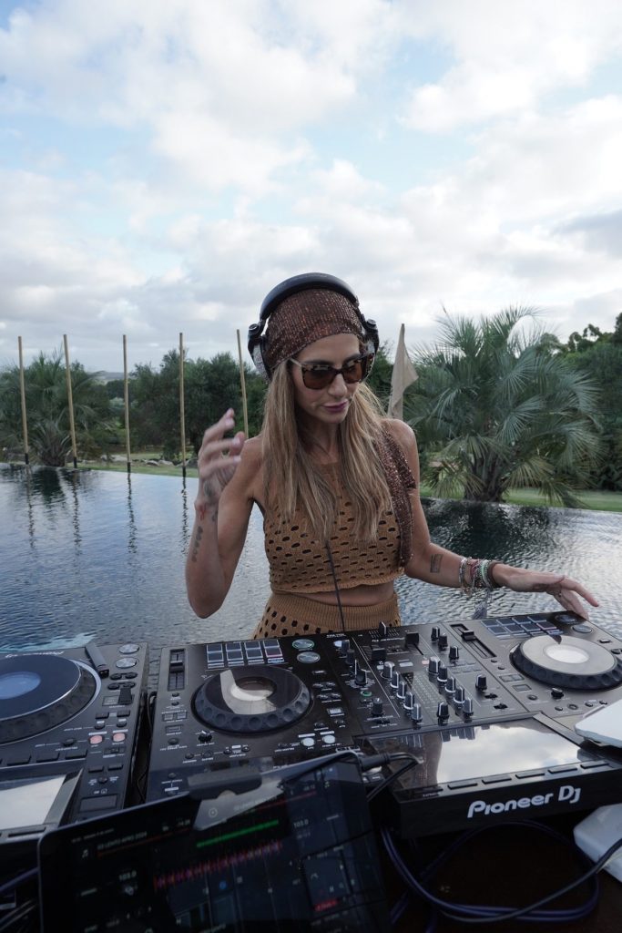 DJ Puli Demaria tocando frente a la serie de 15 postes de madera de Palo. 